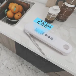 Dettaglio di un termometro digitale bianco con sonda su un bancone da cucina moderno