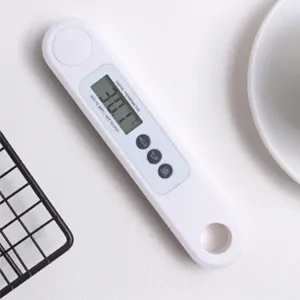 Primo piano di un termometro digitale bianco per alimenti con display LCD e pulsanti