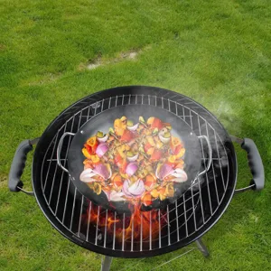 Detail der runden schwarzen Grillpfanne mit Gemüse auf einem heißen Grill im Freien