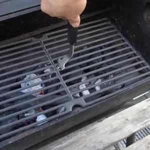 Detail view of a stainless steel BBQ grill grate lifter with an anti-scald handle.
