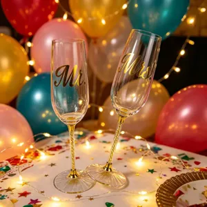 Close-up of Mr. and Mrs. wedding champagne flutes with gold glitter stems and balloons