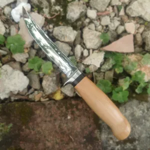 Primer plano de cuchillo de exterior con hoja de acero pulido y mango de madera