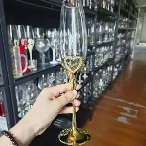 Detailansicht eines luxuriösen Champagnerglases aus Kristall mit goldenem Herzdekor