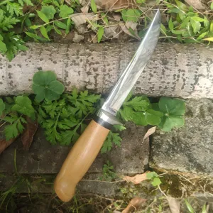 Vista detallada de un cuchillo nórdico para exteriores con mango de madera y acero