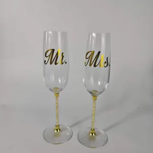 Close-up detail of elegant Mr. and Mrs. champagne flutes with luxury gold filled stems.