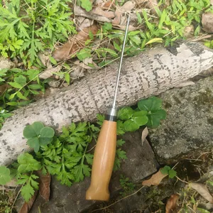 Detalle de un cuchillo de exterior de estilo nórdico con mango de madera maciza natural.