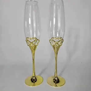 Detailansicht eleganter Sektgläser mit goldenem Stiel und funkelndem Strass-Herz-Dekor