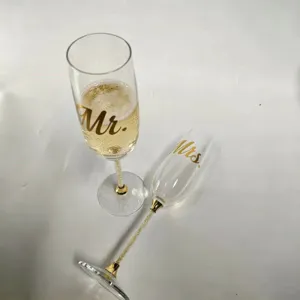 Detailed close-up of luxury crystal champagne flutes with Mr. and Mrs. gold lettering