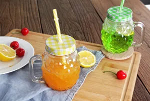 Detailansicht eines 14oz Glases in Ananasform mit frischem Saft und gelbem Strohhalm
