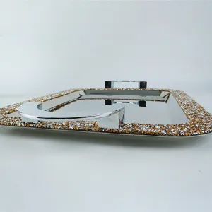Close-up detail of a luxury stainless steel square tray with amber crystal rhinestone rim