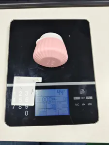 Macro view of a 40ml pink silicone travel bottle being weighed on a digital scale at 44g.