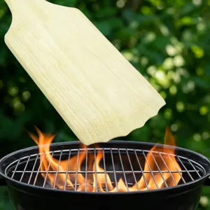 Gros plan d'un grattoir de barbecue en bois avec bord denté pour le nettoyage efficace