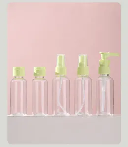 Various clear plastic travel bottles including spray and pump dispensers on pink background