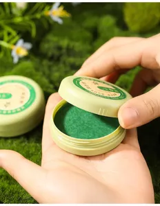Detailbeeld van kruidige kalmerende balsem met de groene textuur in het ronde blikje.