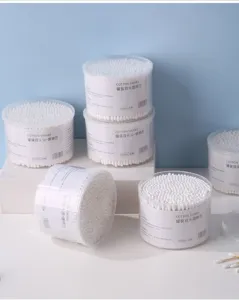 Detailed view of multiple canisters of double-headed disposable white cotton swabs.