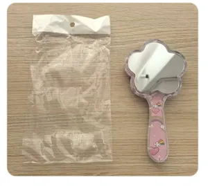Vista detallada del espejo de mano con forma de flor y bonitos estampados de arcoíris rosa