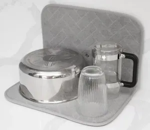 Detalle de un tapete escurridor plegable gris con una olla y vasos en la cocina moderna