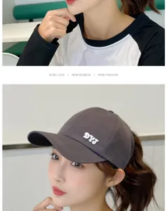 Detalle de una gorra de béisbol gris para mujer con diseño de coleta y letra minimalista.
