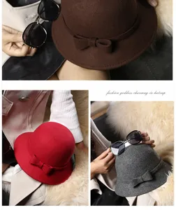 Dettaglio di cappelli cloche in feltro di lana rosso, grigio e marrone con fiocco