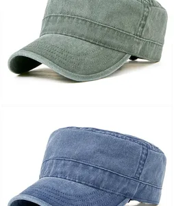 Dettaglio di berretti militari in cotone lavato nei colori oliva e blu con effetto invecchiato.