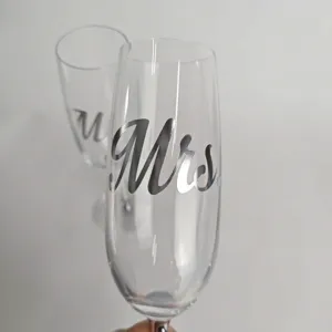 Close-up of elegant crystal champagne flutes featuring Mr and Mrs silver script lettering
