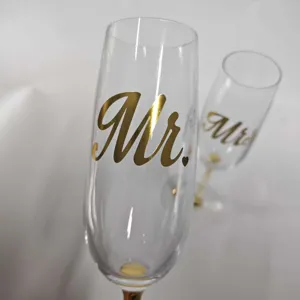 Detailed view of elegant crystal champagne glass featuring a gold foil Mr. decal design
