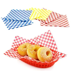 Detail view of red checkered greaseproof paper lining a basket with three fresh donuts