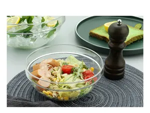 Macro view of a clear acrylic salad bowl filled with fresh pasta and vegetables