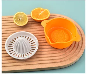 Manual citrus juicer components shown with halved lemon and orange on a wooden tray