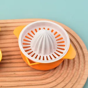 Compact manual plastic citrus juicer squeezer for oranges and lemons on wooden board