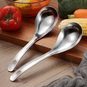 Close-up view of two professional polished stainless steel serving spoons on a board