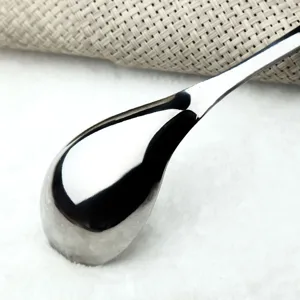 Close-up of a mirror-polished stainless steel soup spoon with elegant water-drop design