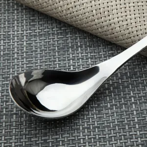 Detailed macro view showing the glossy finish of a polished stainless steel soup spoon