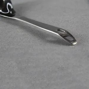 Close-up of stainless steel spoon handle with hanging hole for kitchen storage.