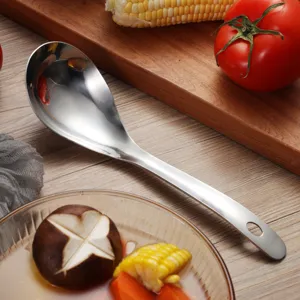 Detailed macro view of a polished stainless steel soup spoon in a rustic kitchen setting
