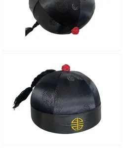 Macro detail of traditional Chinese black silk hat with gold embroidery and red top knot