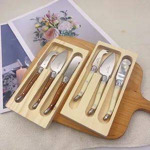 Detailansicht der Laguiole-Käsemesser-Sets mit cremefarbenen und Holzmaserungsgriffen.
