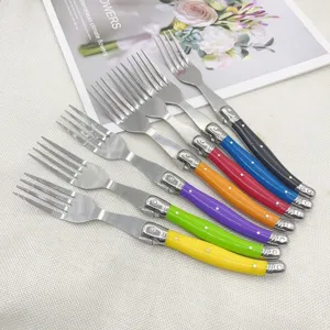 Array of colorful stainless steel Laguiole-style forks on a decorative background