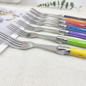 Close-up of vibrant Laguiole style steak forks with signature bee motif engraving