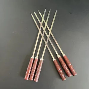 Set aus 6 Grillspießen aus Edelstahl mit ergonomischen Holzgriffen auf dunklem Grund.
