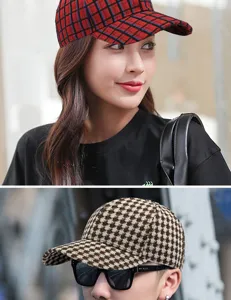 Detail view of stylish houndstooth and red plaid baseball caps for men and women