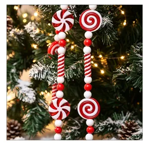 Close-up of red and white Christmas candy bead garland ornaments hanging on a pine tree