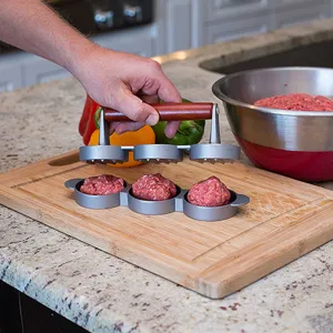 Manual 3-hole hamburger patty press mold with wooden handle used on a wooden board