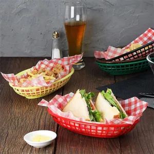 Set of colorful plastic fast food baskets filled with sandwiches and fries on a wooden table