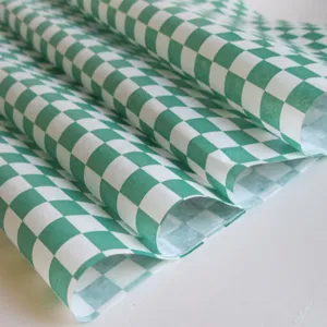 Detailed close-up of green checkered greaseproof paper texture for food wrapping