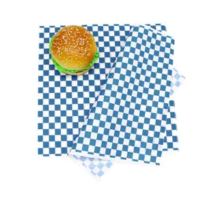 Detailed view of blue checkered greaseproof wax paper showing application with a burger
