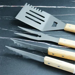 Close-up of stainless steel BBQ tools with natural oak handles on a dark background