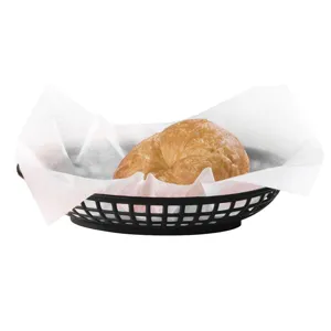 Close-up of black plastic food basket with a croissant on white greaseproof paper.
