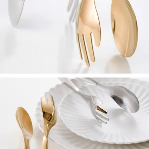 Detailed view of gold and silver stainless steel serving tongs on white decorative plates