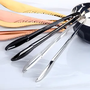 Détail de pinces alimentaires en inox coloré avec pointes dentelées et poignées texturées.